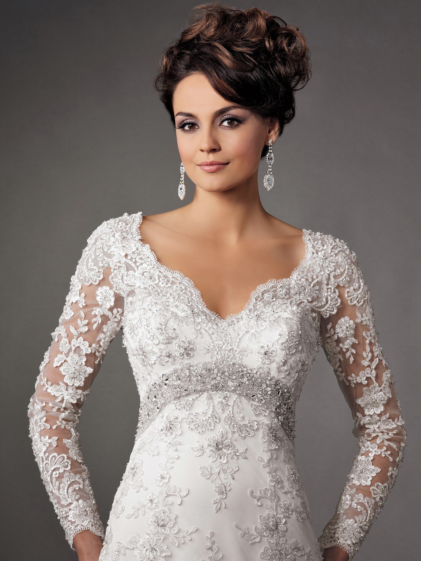 A white dress with a high neckline, long lace sleeves, and a slit up the leg